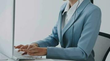 Call center agent with headset working on support hotline in modern office with copy space. Portrait of mature positive agent in conversation with customer over headset looking at camera. video