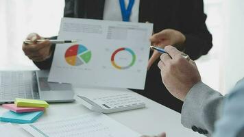 Financial analysts analyze business financial reports on a digital tablet planning investment project during a discussion at a meeting of corporate showing the results of their successful teamwork. video