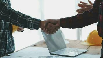 Architect and engineer construction workers shaking hands while working for teamwork and cooperation concept after finish an agreement in the office construction site, success collaboration concept video