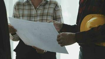 arquiteto e engenheiro construção trabalhadores tremendo mãos enquanto trabalhando para trabalho em equipe e cooperação conceito depois de terminar a acordo dentro a escritório construção site, sucesso colaboração conceito video