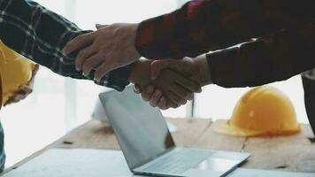 Architect and engineer construction workers shaking hands while working for teamwork and cooperation concept after finish an agreement in the office construction site, success collaboration concept video