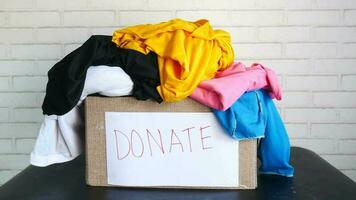 Donation box with donation clothes on a wooden background video