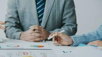 Financial analysts analyze business financial reports on a digital tablet planning investment project during a discussion at a meeting of corporate showing the results of their successful teamwork. video