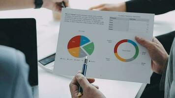 Financial analysts analyze business financial reports on a digital tablet planning investment project during a discussion at a meeting of corporate showing the results of their successful teamwork. video