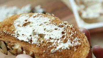 Low fat cheese cream spread on a bread on table video