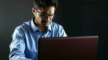 Young man working on laptop stealing personal data video