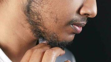 Side view of young man touch this growing beard , video