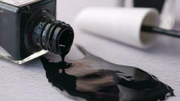 Black color nail polish spilling on table video