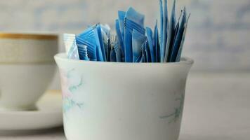 Sugar Substitute sweetener packet and tea cup on white background video