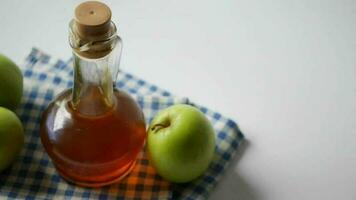 apple vinegar in glass bottle with fresh green apple on table video