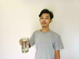 Asian man has a glass of water on isolated background photo