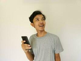 Surprise face asian man use smartphone and facing up with copy space of advertisement photo