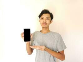 Asian young man showing smartphone with blank screen photo