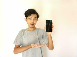 Asian young man showing smartphone with blank screen photo