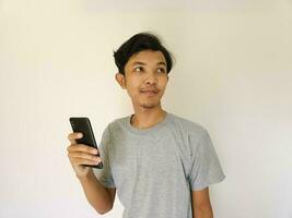 Surprise face asian man use smartphone and facing up with copy space of advertisement photo