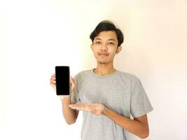 Asian young man showing smartphone with blank screen photo