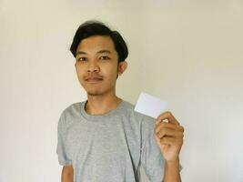 Happy funny face Asian man show off his empty card on white background photo