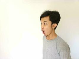 Shocked and surprised face of Asian man in isolated on white background photo