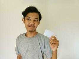 contento gracioso cara asiático hombre espectáculo apagado su vacío tarjeta en blanco antecedentes foto