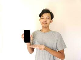 Asian young man showing smartphone with blank screen photo