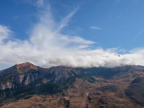 Mountain in the white clouds. Bright atmospheric scenery on top of mountain ridge above clouds in thick low clouds.  Beautiful mountain foggy scenery on abyss edge with sharp stones. photo