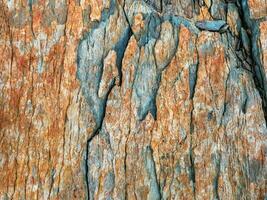 Layered mountain texture. Stone texture. Cross section of rocks. Geological layers. Colored layers of stones in section of the mount, different rock formations and soil layers. photo