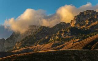 Twilight Mountains. Majestic glacier is illuminated by the bright golden evening sun. Panoramic view. Big Caucasus Mountains. photo