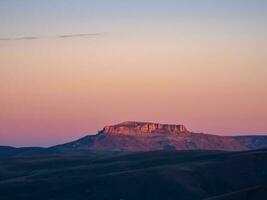 Magical magenta dawn over the Bermamyt plateau. Atmospheric dawn landscape with beautiful Bermamyt plateau is in the distance. photo