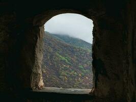 Old stone window. View through arched window in old stone abandoned church. Architecture concept. photo