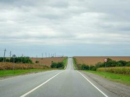 Soft focus. Highway through the autumn cornfield natural way con photo