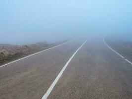 Highway through the pass in thick fog. photo