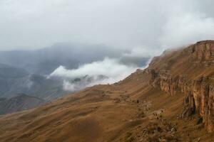 bermamyt meseta. brumoso montaña ver desde acantilado a muy alto altitud. escénico alpino paisaje con hermosa agudo rocas en amanecer. hermosa paisaje en abismo borde con agudo piedras foto