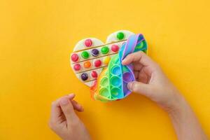 Children is  hands take out the prepared chocolate with their own hands from the popit silicone mold. Use the popular pop it toy as a chocolate mold. Step-by-step photo instructions. Step 8.