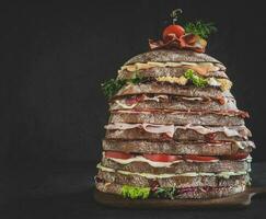 Huge sandwich on dark background photo