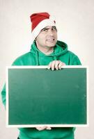 Man holding a blackboard wearing Santa hat photo