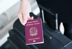 Hand holding Italy passport, ready to travel photo