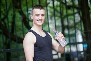 Handsome athlete man drinking water photo