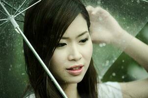Beautiful girl is standing with umbrella  among a rain 2 photo