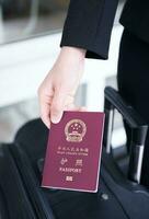Hand holding China passport, ready to travel photo