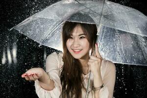 contento chino niña con lluvia y transparente paraguas foto