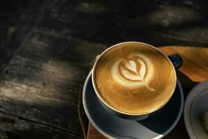 parte superior ver de café latté Arte con tulipán modelo en parte superior en rústico de madera mesa bar en difícil Mañana ligero con Copiar espacio foto