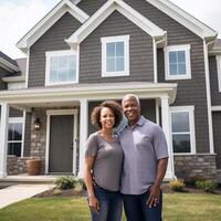 Portrait of happy mature couple standing in front of their new house photo