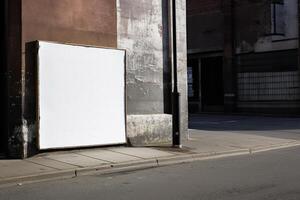 A blank white billboard mockup on a sidewalk in a city photo