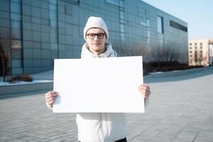 A man holds a blank white sign board mockup in his hand photo