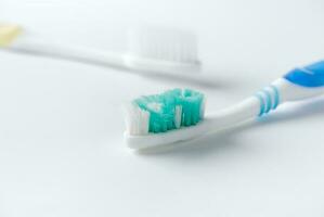 Used toothbrush and new toothbrush on white background photo