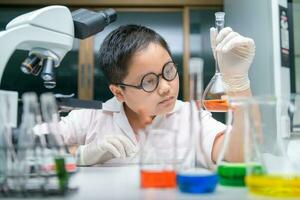 Kid scientist making experiment in chemical laboratory, photo
