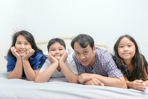 Asian Happy young family lying in bed together photo