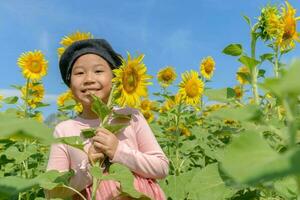 cute Asian girl smile with sunflower flower photo