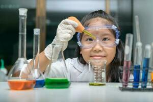 Little scientist wearing safty goggle  making experiment. photo