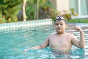 Obese fat boy show muscle in swimming pool photo